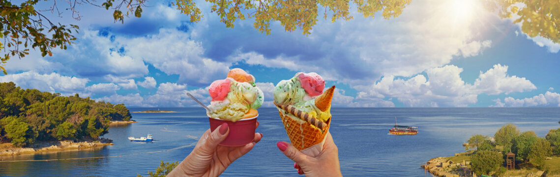 Wonderful romantic summer afternoon landscape panorama of a couple with beautiful bright sweet ice cream of different flavors in the hands and sea on background. Green lagoon sea bay in Porec, Croatia