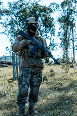 Naklejka premium Anonymous soldier with AK-47 in the middle of the battlefield