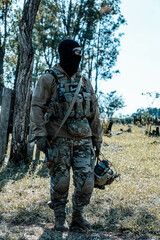 Fototapeta premium Anonymous soldier with AK-47 in the middle of the battlefield