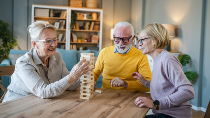 Group of people senior man and women play leisure board game at home