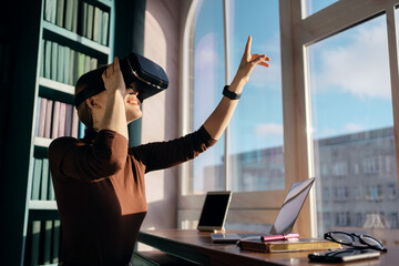A woman in a library wearing a vr headset.