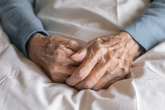 Hands of an old women close up on a bed in a hospital. Aging process, elderly women