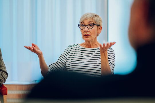 Senior woman talking about her mental health on a group therapy session