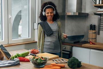 A beautiful happy woman is having fun cooking