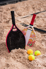 Women's and children's beach tennis rackets on the sand. Beach tennis mother's day. Beach Tennis Kids. Mother and daughter at beach tennis. Copy space.