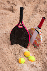 Women's and children's beach tennis rackets buried in the sand. Beach tennis mother's day. Beach Tennis Kids. Copy space - Vertical Photo