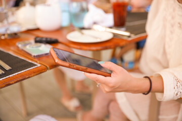 people holding phones at a dining table symbolizes the prevalence of technology in our modern lives, but also the potential distraction and lack of presence in social situations