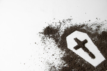 front view of coffin shape with dark soil and cross on white surface grim reaper death funeral