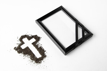 front view of cross shape with picture frame on white surface soil death grim reaper funeral