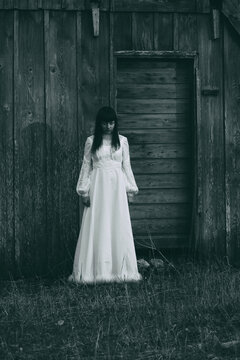 Horror scene of woman in white dress. Bluish vintage look