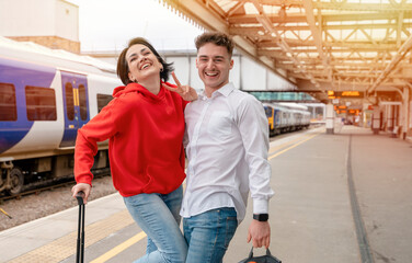 Beautiful couple at railway station waiting for the train. Woman and man running to board a train