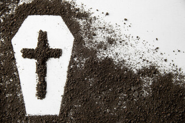 top view of coffin shape with dark soil and cross on white surface grim reaper death