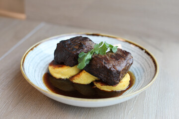 Sous Vide Plated Boneless Braised Short Rib, Red Wine Reduction, served over a Grilled Polenta Corn Meal Cake