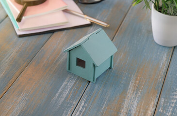 Toy house on a wooden table on wooden background. Mortgage property insurance dream home concept