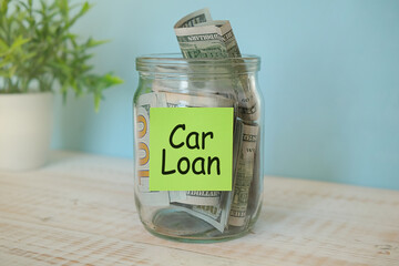 puts 100 dollars in a glass jar with the text car. Concept of saving money.