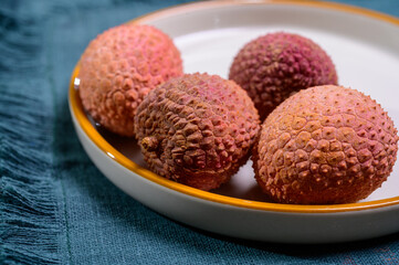 Tasty tropical exotic fruits, ripe fresh unpeeled lychee fruits