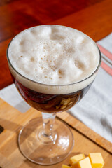 Pouring of Belgian abbey brown beer in glass close up