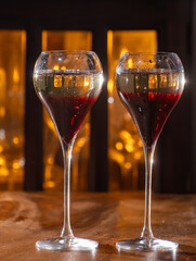 Drinking of Kir Royal, French aperitif cocktail made from creme de cassis topped with champagne, typically served in tulip glasses
