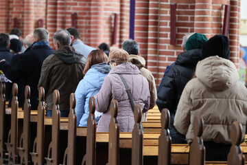 Wierni, ludzie na mszy świętej w kościele katolickim.  - obrazy, fototapety, plakaty