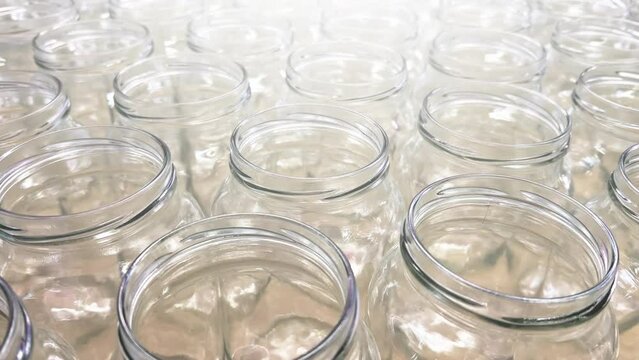 Rows of new clear glass jars for canning stand in the kitchen supply store