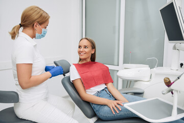 Fototapeta premium Portrait of friendly female doctor and patient at dentist's office