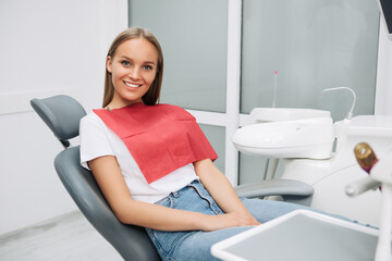 The girl is at the reception at the dentist. Dental bleaching. Dental clinic. Treatment of teeth in a modern clinic. Restoration of a healthy smile.