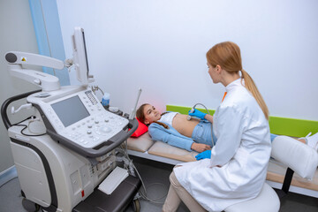 Doctor performing ultrasound scan on little girl medical specialist examining child abdominal cavity