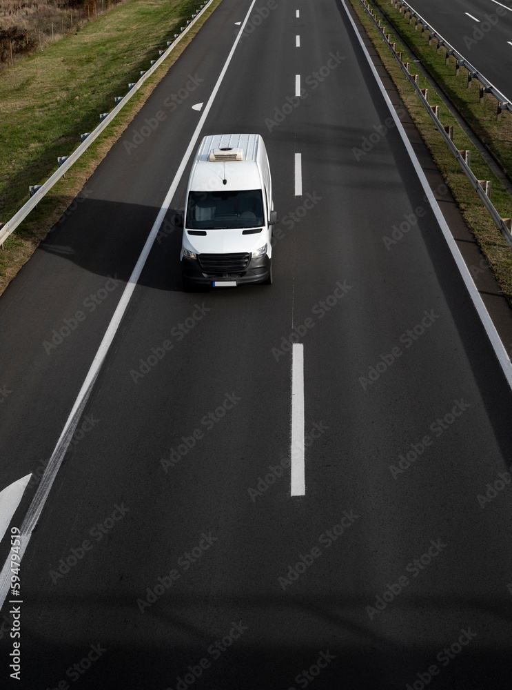 Wall mural white delivery van on the highway. white modern delivery small shipment cargo courier van moving fas