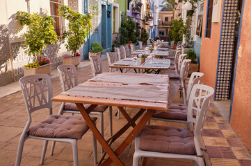 Fototapeta na wymiar Historic center of the old town of Calpe.Calpe town with colorful houses and restaurant terraces.A place to eat in restaurants on a terrace street.Spain