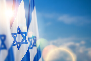 Israel flags with a star of David over cloudy sky background on sunset. Banner with place for text.