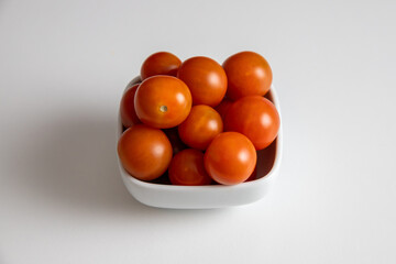 cherry tomatoes in a bowl on white background