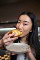 Young Asian female eating dessert in a coffee shop