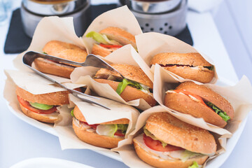 Burger mini burgers snacks on a wooden table with craft paper, beautifully decorated catering banquet table on corporate christmas birthday party event or wedding celebration