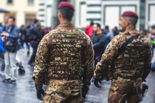 Italian armed forces squad patrol formation back view in military army uniform with red beret maintain public order and patrolling in the streets of Venice, Venezia, Italy