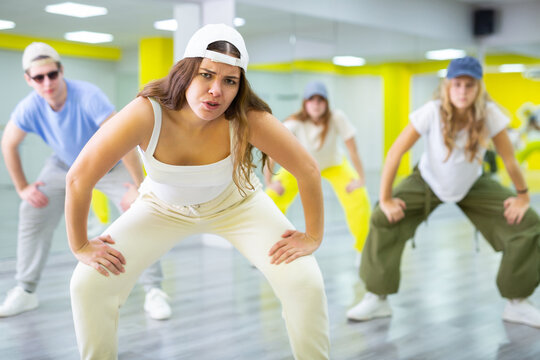 Young girl in cap dancing hip hop dances in dance studio