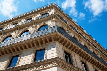 The facade of traditional French house with typical balconies and windows. Paris.