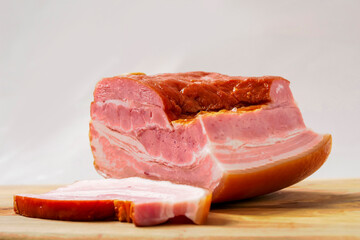 Traditional smoked Polish ham on a wooden cutting board. Popular East European food for any occasion. Pork product of high premium quality.