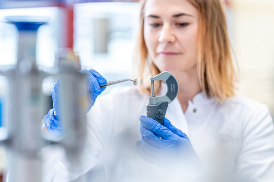 young woman scientist measures a sample in the laboratory