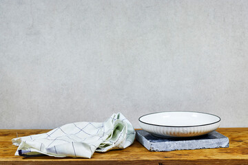 Empty wooden table with white plate above tablecloth on blue marble podium or stone beauty. Product promotion Beauty cosmetic showcase on wooden table