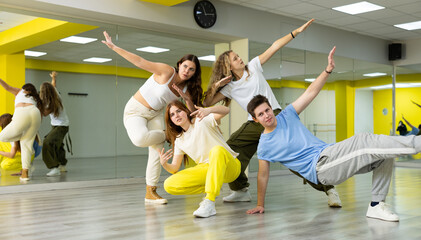 Teenage dancers young people practicing modern dance styles together in spacious studio with mirrors