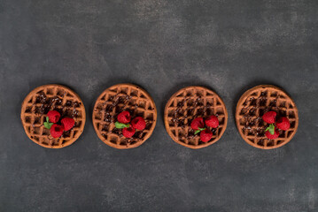 Obraz na płótnie Canvas Desert Cacao round waffles with raspberries.. Dark gray background. Top view