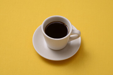 Obraz na płótnie Canvas 黄色いテーブルの上に置かれたホットコーヒー