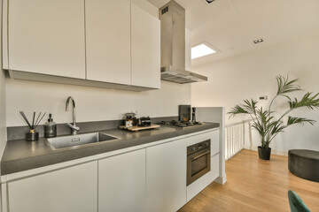 a modern kitchen with white cabinets and black counter tops on the island in front of the sink is next to the dishwasher