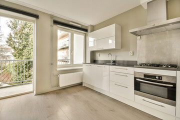 a kitchen with white cabinets and an open door leading to the outside patio, which looks out onto...