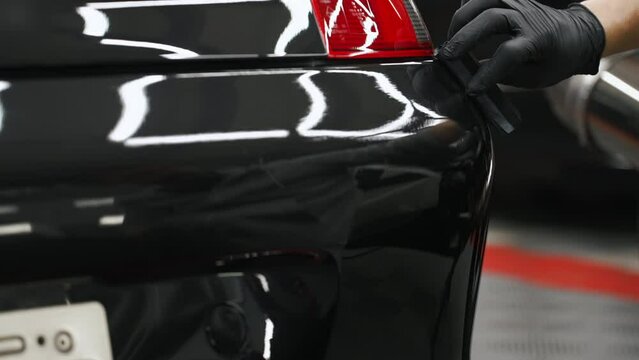 Car rear having ceramic coating put on. Repair shop concept. Black car. High quality 4k footage