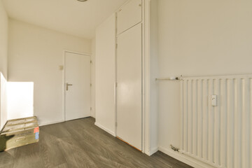 an empty room with wood floors and white radiangs on the wall in the room is very clean