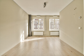 an empty room with wood flooring and light colored paint on the walls, white trim around the window panes