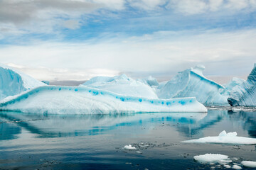 Turquoise, Blue and White Icebergs Relected in Smooth Glassy Water in Antarctica Near Cuverville Island © Jill Clardy