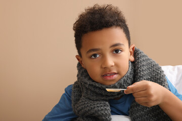 African-American boy taking cough syrup on bed at home, space for text. Cold medicine
