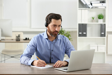 Fototapeta premium Hotline operator with headset working in office